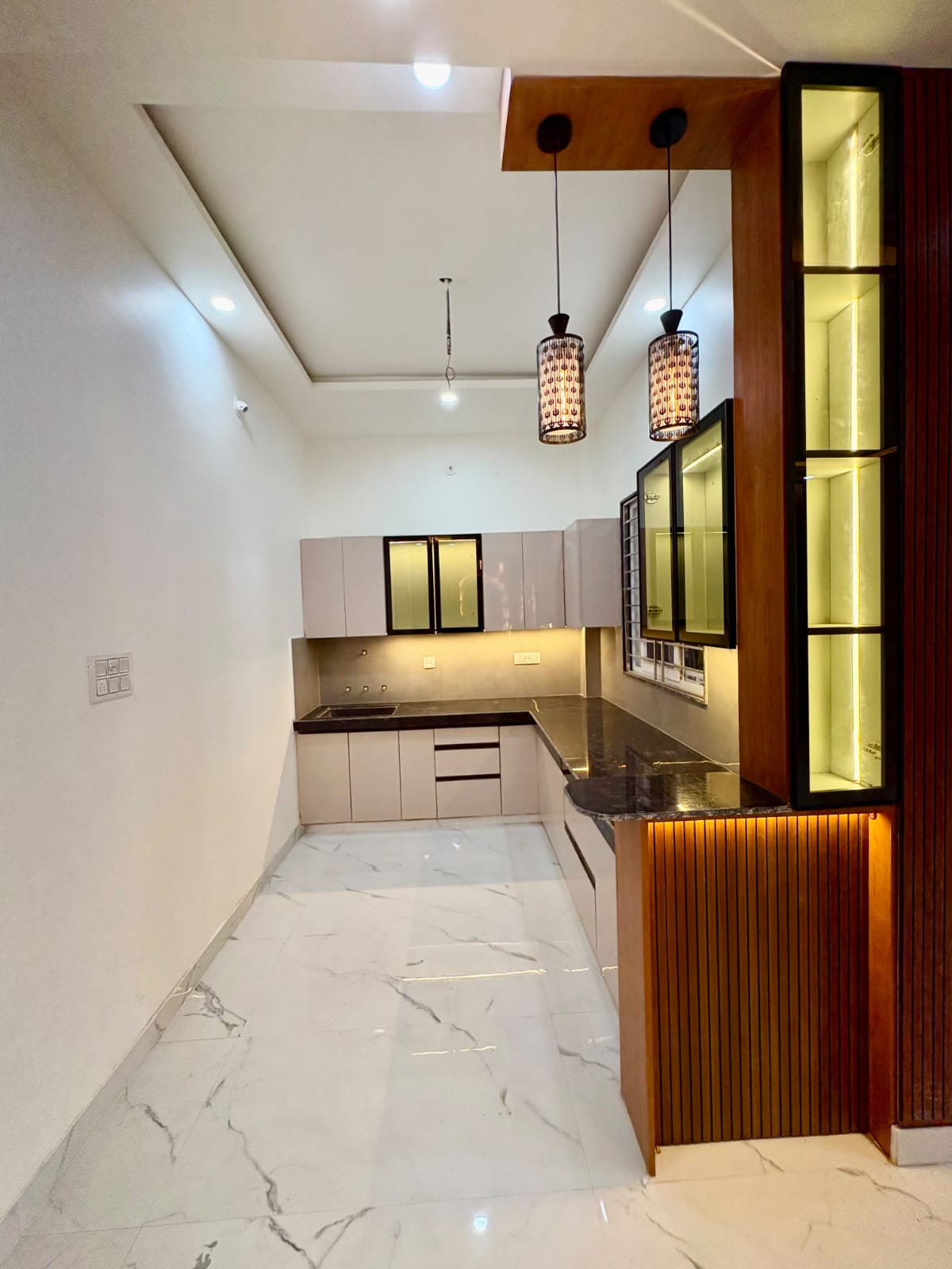 Modern modular kitchen design with fluted breakfast counter and pendant lighting
