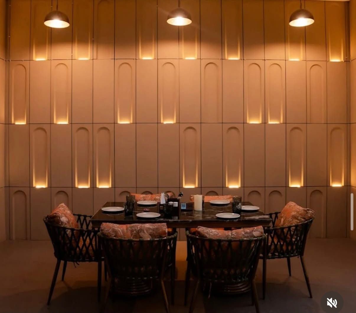 Luxury dining space with recessed illuminated wall arches and marble dining table