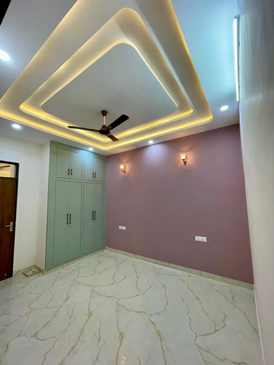 Perspective view of bedroom showing bespoke built-in wardrobe craftsmanship, smooth vitrified marble tile joints, and warm lighting