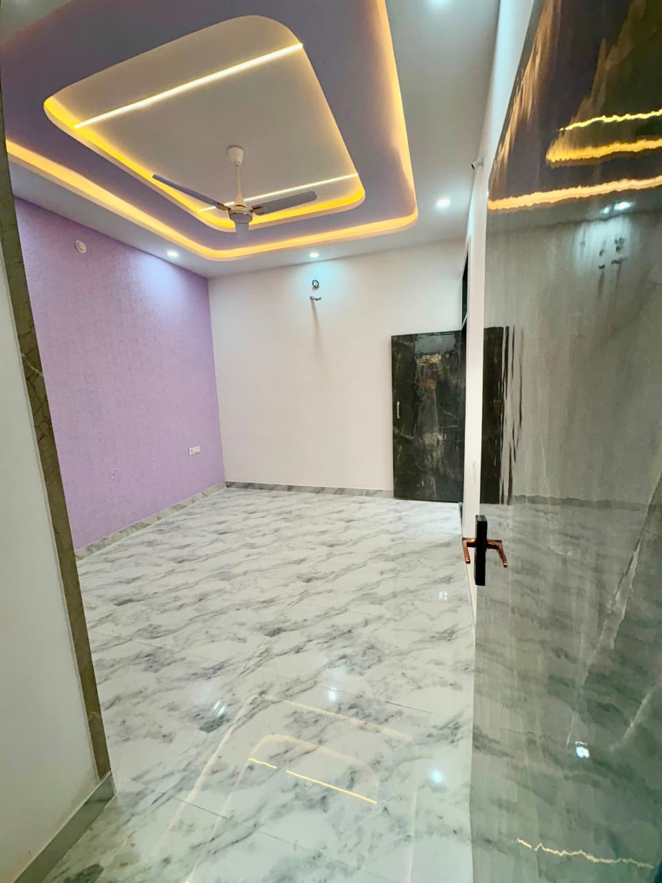 Spacious guest bedroom featuring lavender accent feature wall, Italian marble-look tiling, and modern recessed ceiling design