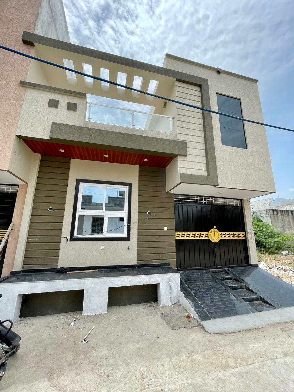 Modern 2-story residence facade with roof pergola, glass balcony, and driveway entrance in Kota