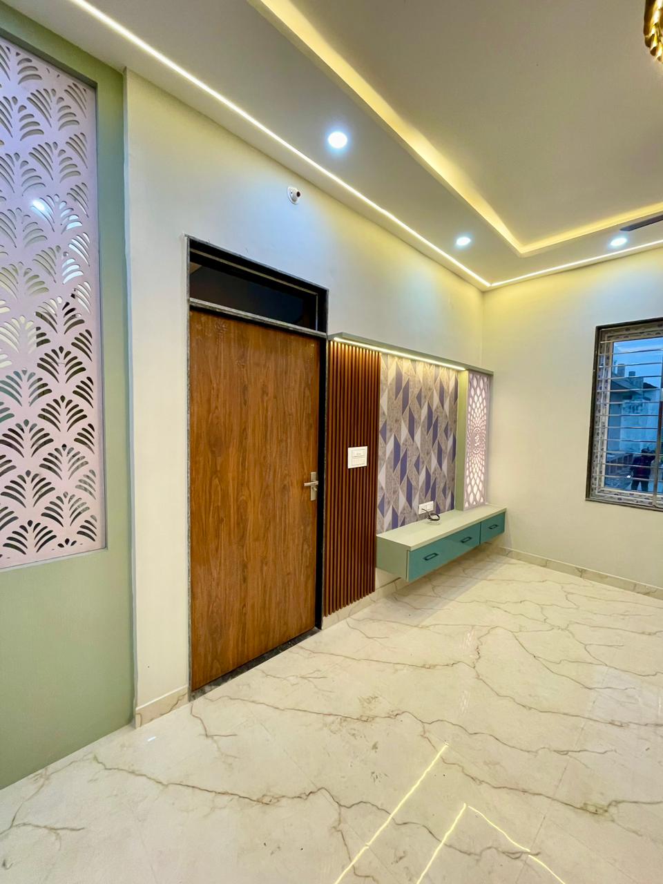 Living room entrance view featuring fluted accent timber wall, suspended entertainment console, and pastel green jali divider